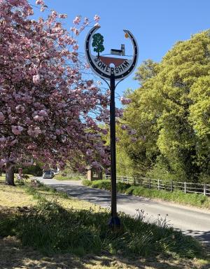 Village sign MAY shelter and bus